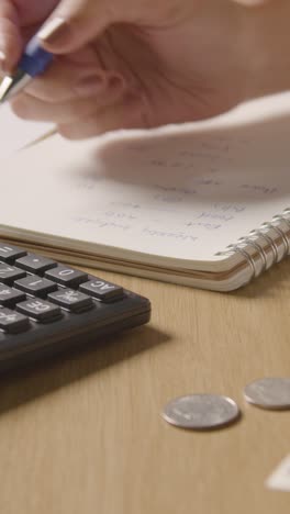 Vertical-Video-Of-Woman-With-Dollar-Notes-And-Coins-Using-Calculator-To-Budget-For-Household-Bills-In-Cost-Of-Living-Crisis-2